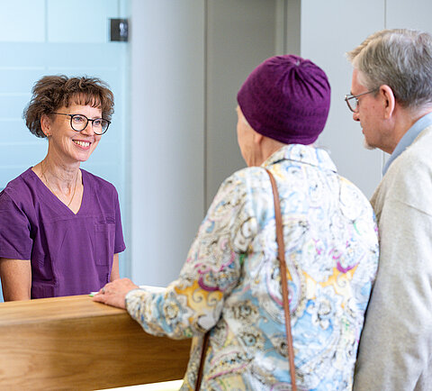 Zwei Patienten werden von zwei Angestellten in der Onkologie Darmstadt begrüßt.