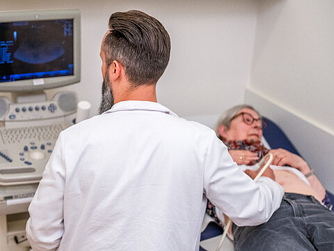 Ein Arzt der Onkologie Darmstadt untersucht eine Patientin.