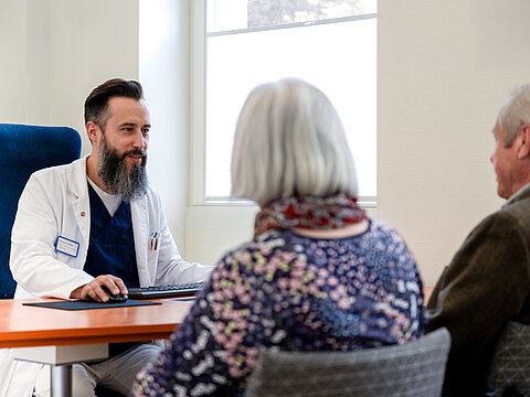 Ein Arzt der Onkologie Darmstadt im Beratungsgespräch mit zwei Patienten.